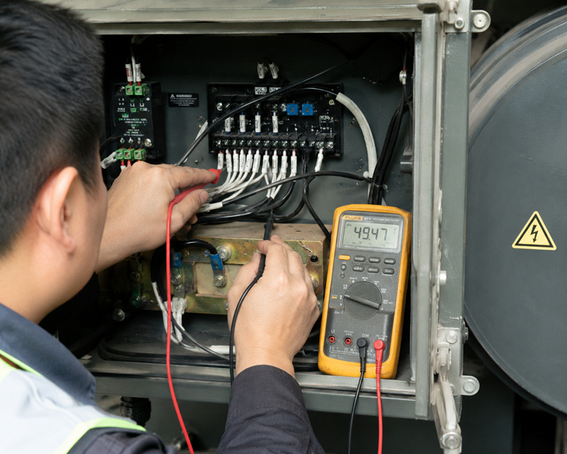 Technician testing a generator AVR with a multimeter