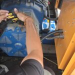 Technician inspecting diesel generator alternator terminal connections
